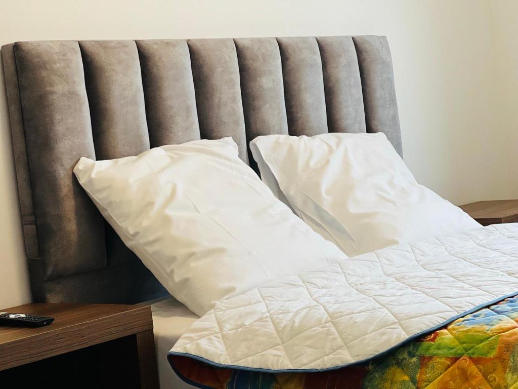 ein Bett mit weißen Kissen darüber in der Unterkunft Auberge de Bagneux in Bagneux