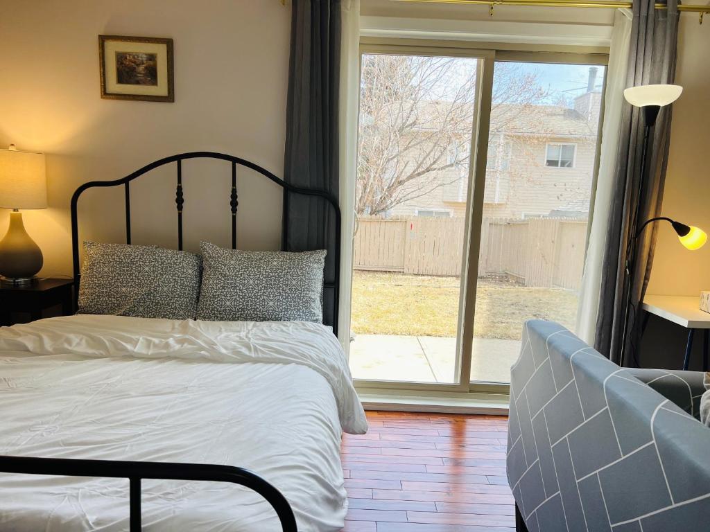 1 dormitorio con cama y ventana grande en Lily room near golf and banff costco newly renovated queen size bed Single bathroom sofa TV, en Calgary