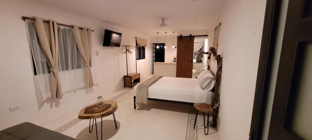 ein Schlafzimmer mit einem weißen Bett in einem Zimmer in der Unterkunft Pakáal Muliix - Limóm in Mérida