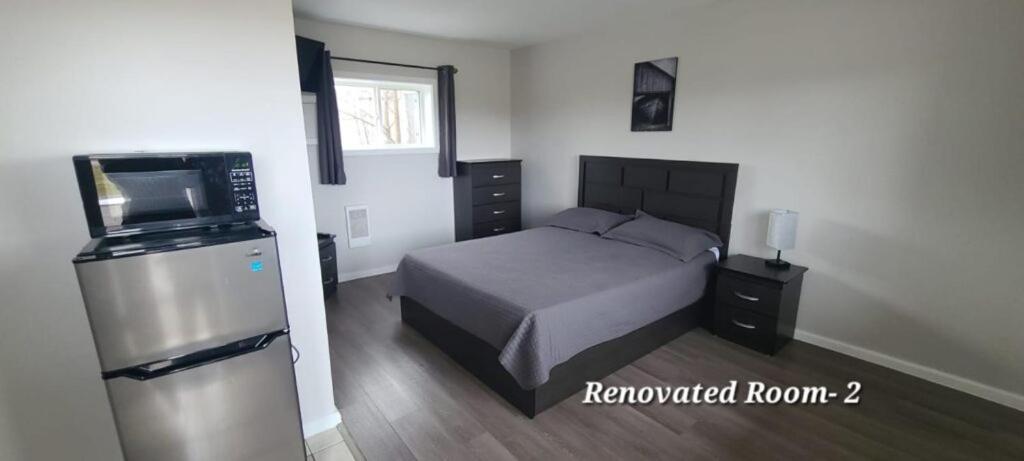 una camera da letto con un letto e una televisione di Tay Motel a Waubaushene