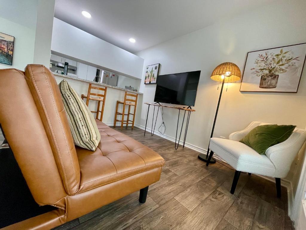 a living room with a leather couch and a television at Cabo San Roman entire Condo with patio 5 min from Casino in Lake Charles