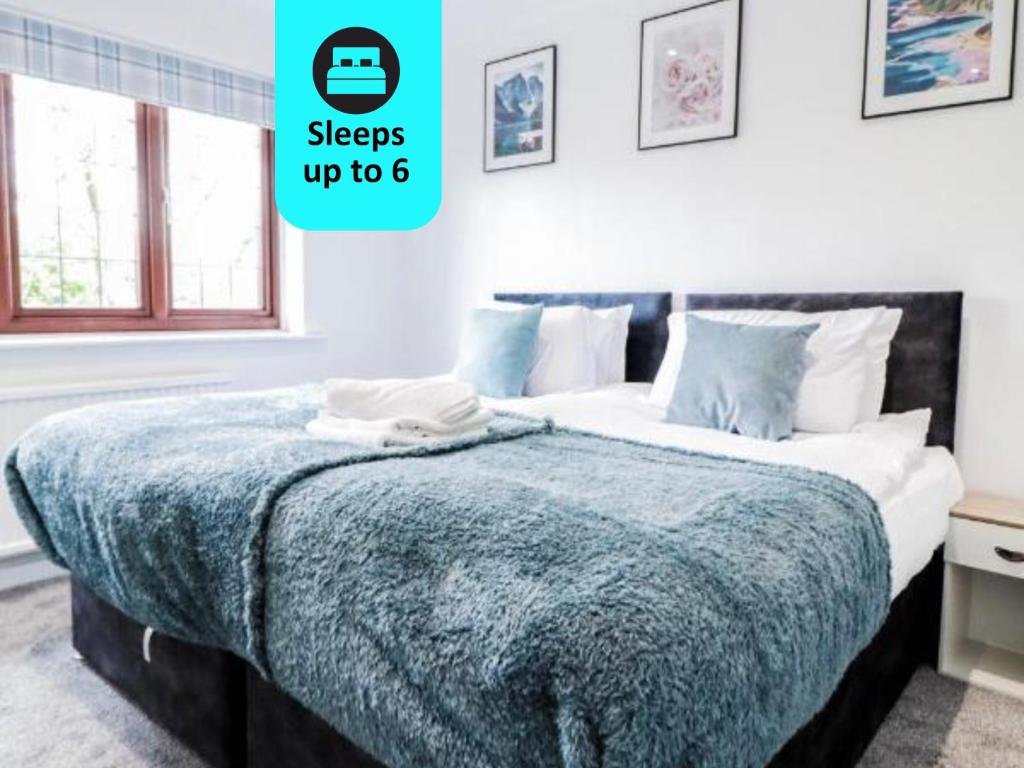 a bedroom with a bed with a blue blanket at Tranquil 3BR Retreat for Families in Bexleyheath in Bexleyheath