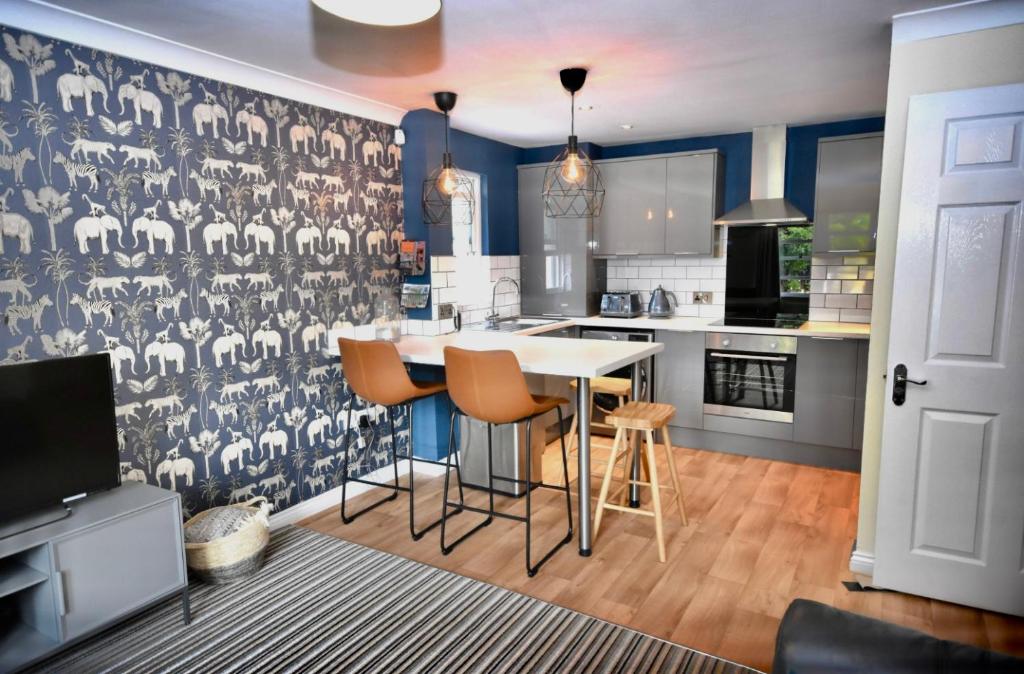 een keuken met blauwe muren en een witte tafel met krukken bij The Sidings, Durham in Durham