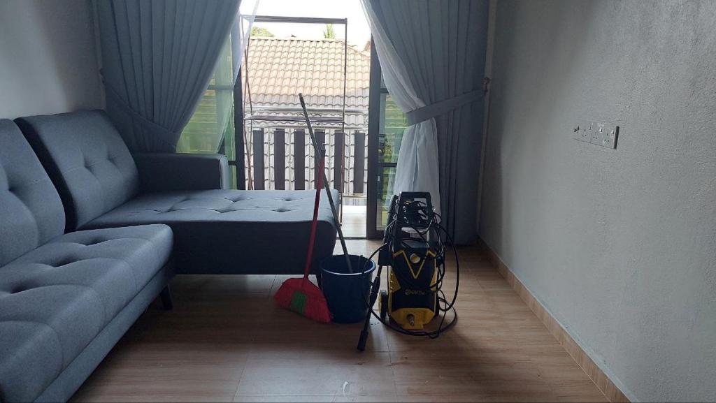 ein Zimmer mit einem Wohnzimmer mit Sofa und Skiausrüstung in der Unterkunft IIY Homestay in Pasir Mas