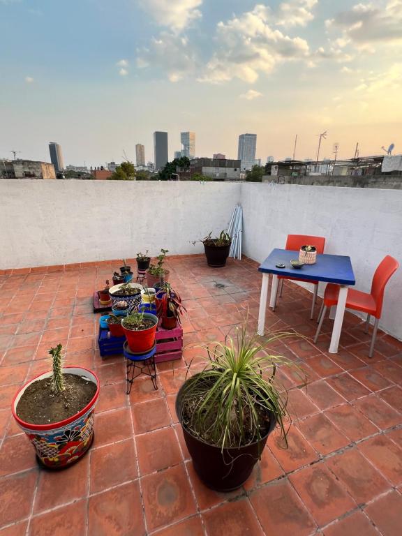 a patio with potted plants and a table and chairs at Rooftop Paradise Central Location, Scenic Views in Mexico City