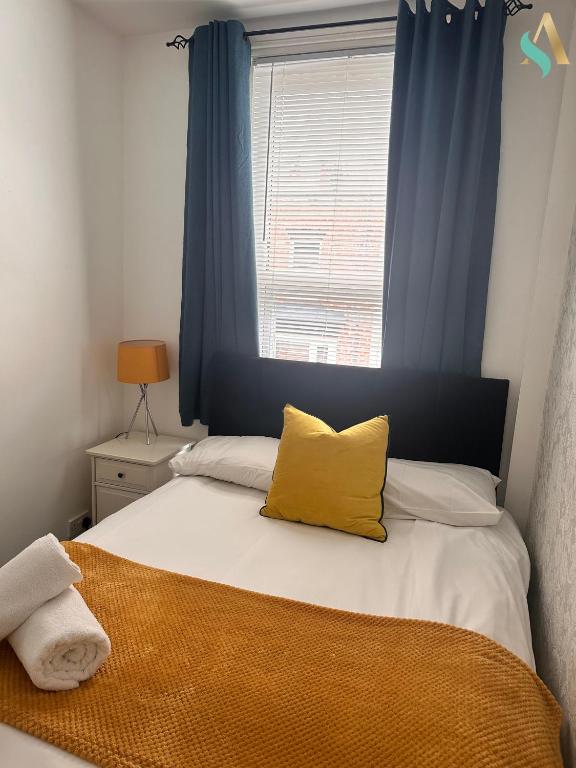 a bedroom with a bed with a yellow pillow on it at Milton Road Flat 2 - TSAC in Hartlepool
