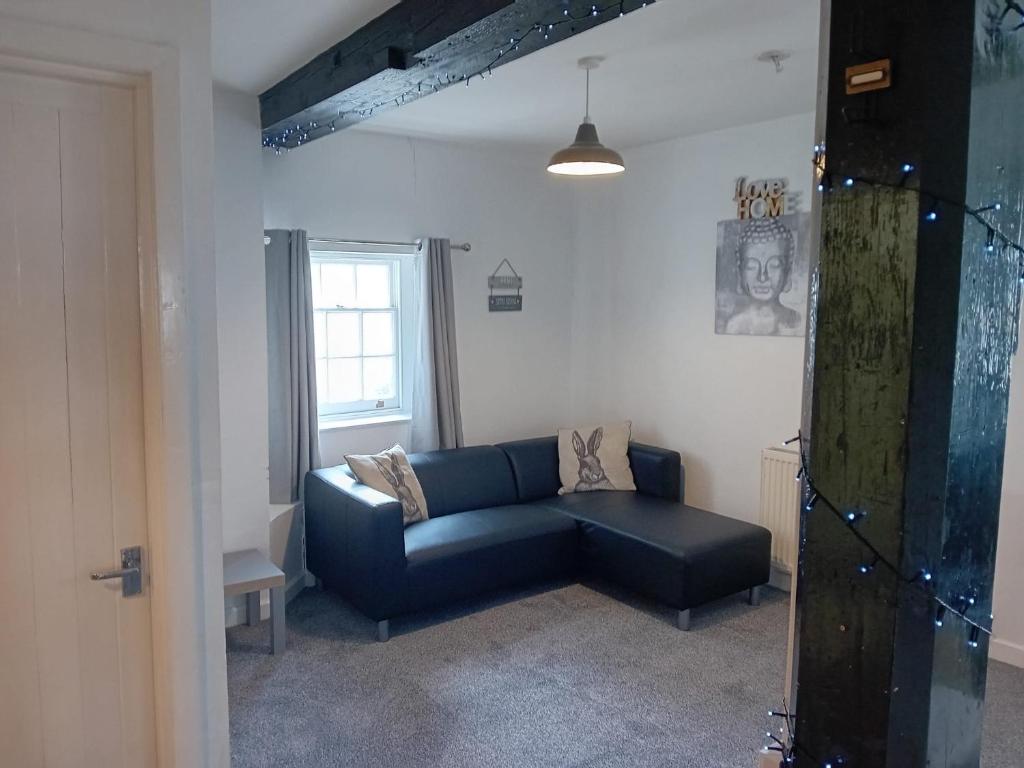 sala de estar con sofá azul y ventana en Apartment in Historic Mill, near Dover Port en Kent