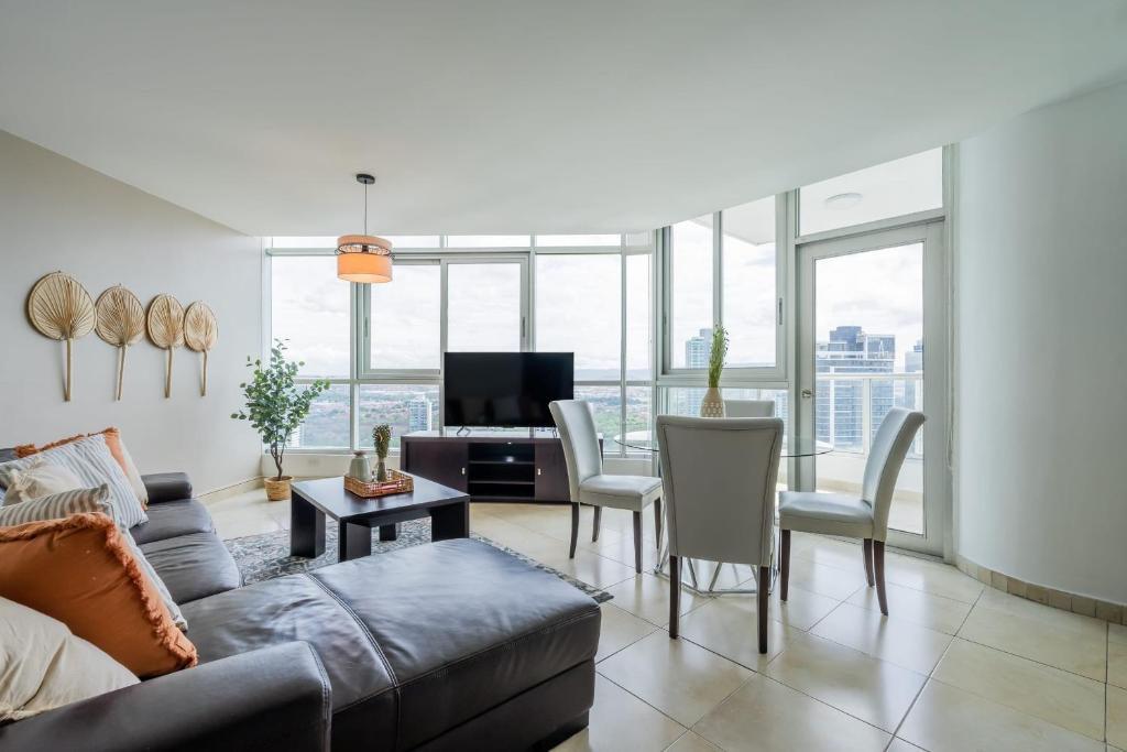 a living room with a couch and a table with chairs at Fantastic 2BR with balcony in Costa del Este in Panama City