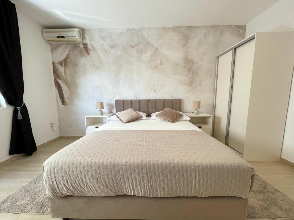 a bedroom with a large bed and a marble wall at Apartments Marija Magdalena in Hvar