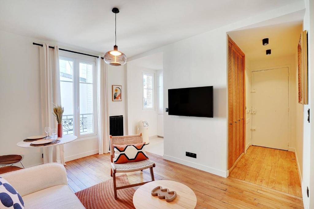 sala de estar con sofá y TV en Luxury flat silly - Boulogne city center, en Boulogne-Billancourt