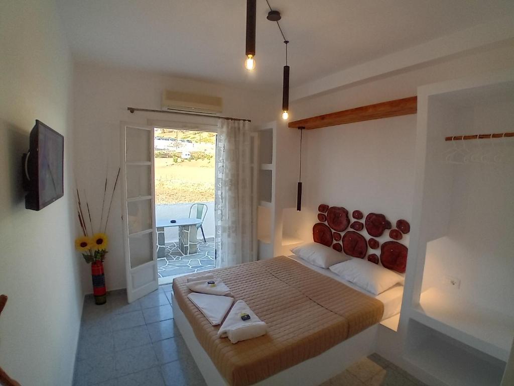 1 dormitorio con 1 cama en una habitación con ventana en Nikolas ios Village, en Ios Chora