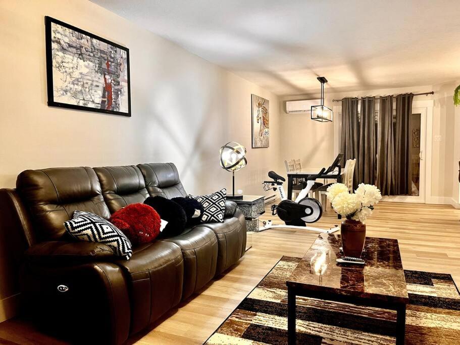 a living room with a leather couch and a table at New built home close to airport in Dieppe