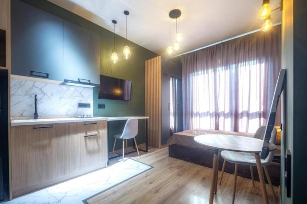 トビリシにあるA-Y Apartments P A4のテーブル付きの部屋、ベッド付きのキッチンが備わる客室です。