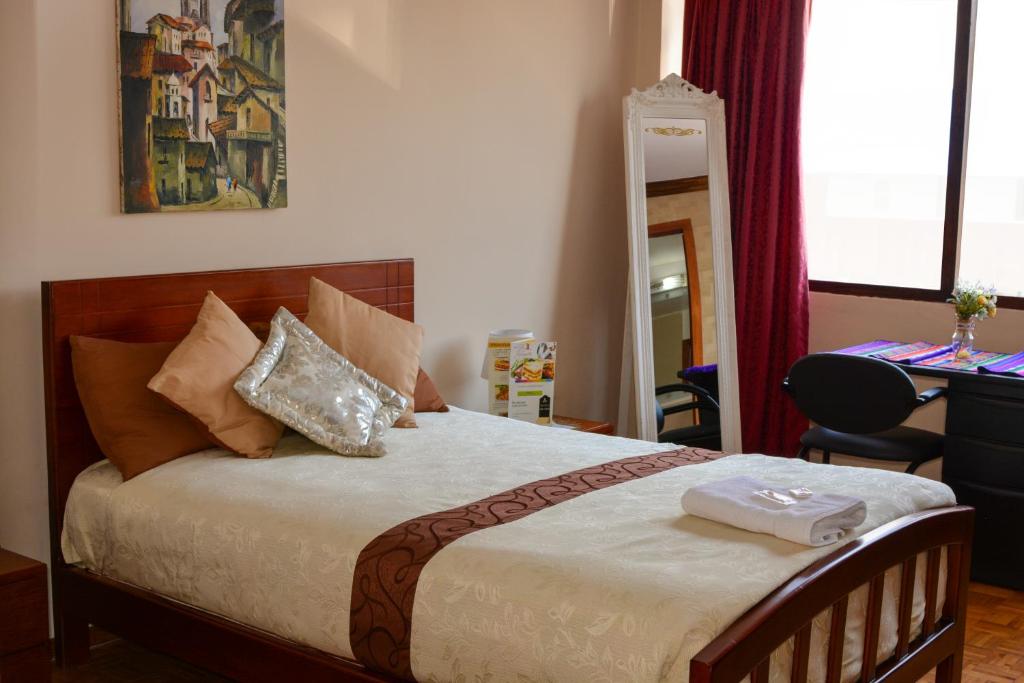 Hotel Villa Lafayette في كيتو: غرفة نوم عليها سرير وفوط