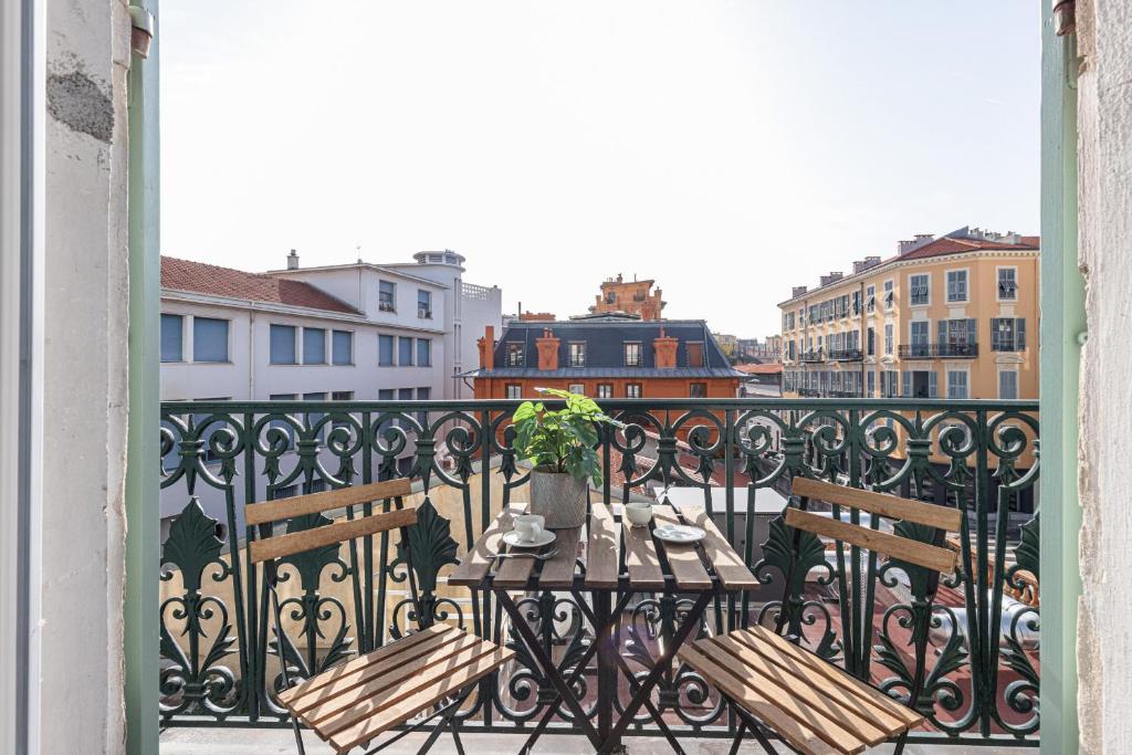 un balcon avec deux bancs et une table avec une plante dans l'établissement 7 FOCH 202 - Studio contemporain en plein coeur de Nice - climatisation, à Nice