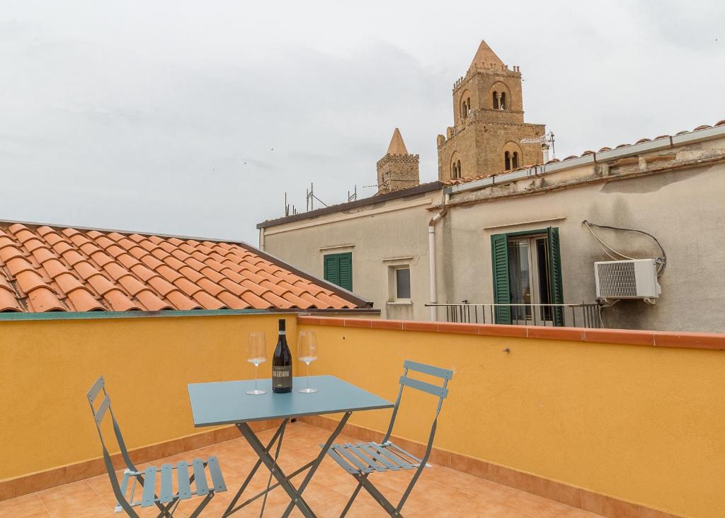 - une table et des chaises sur un balcon avec une bouteille de vin dans l'établissement Bedda Casa, à Cefalù