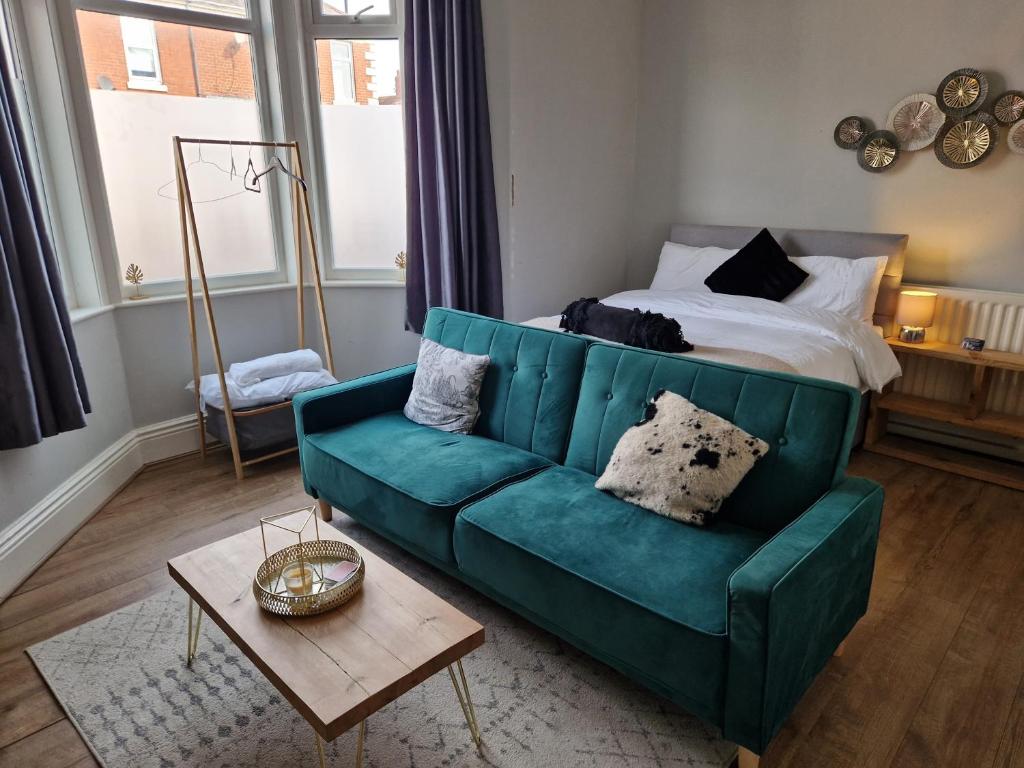 a living room with a green couch and a bed at West Beck House - Newcastle 2 in Newcastle upon Tyne