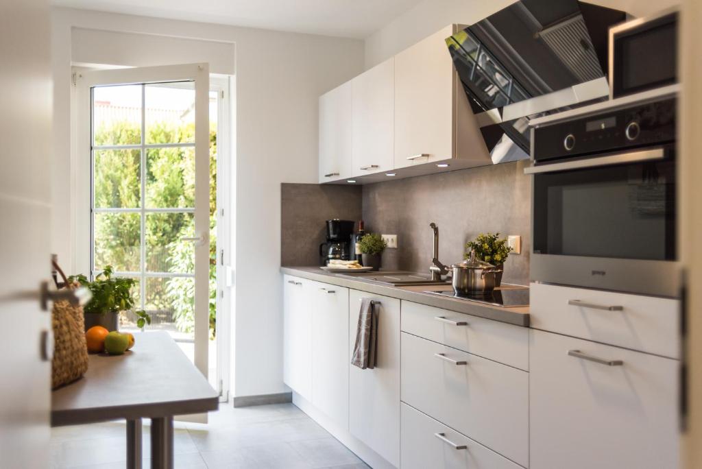 a kitchen with white cabinets and a table and a window at Birkenstraße 6 Haus II Whg3 in Zingst