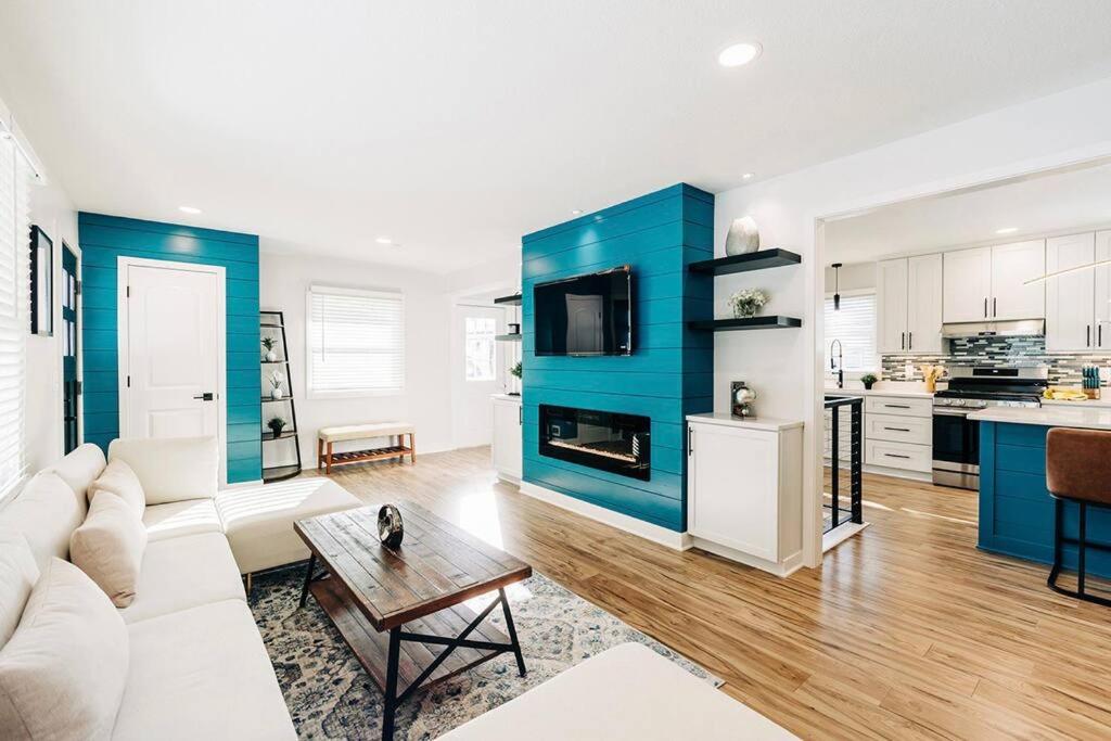 a living room with a white couch and a blue wall at Beautiful luxury home freshly renovated with big yard, seating & grill pad in Cottage Grove