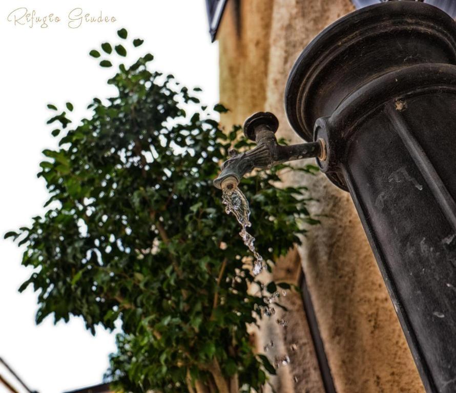 a water tap on the side of a building with a plant at Rifugio Giudeo in Balestrate