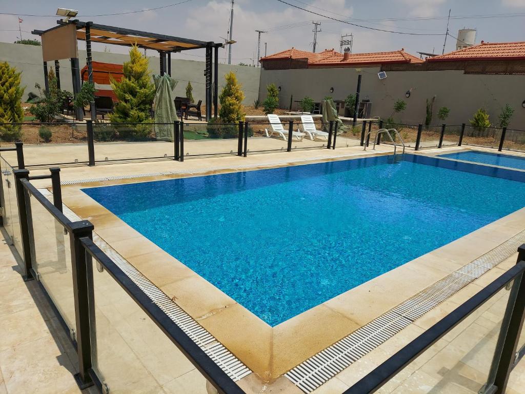 a large swimming pool with blue water at Giving Paradise Chalet in Amman