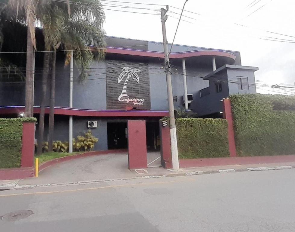 a building with a palm tree on the side of it at Hotel Coqueiros in Carapicuíba