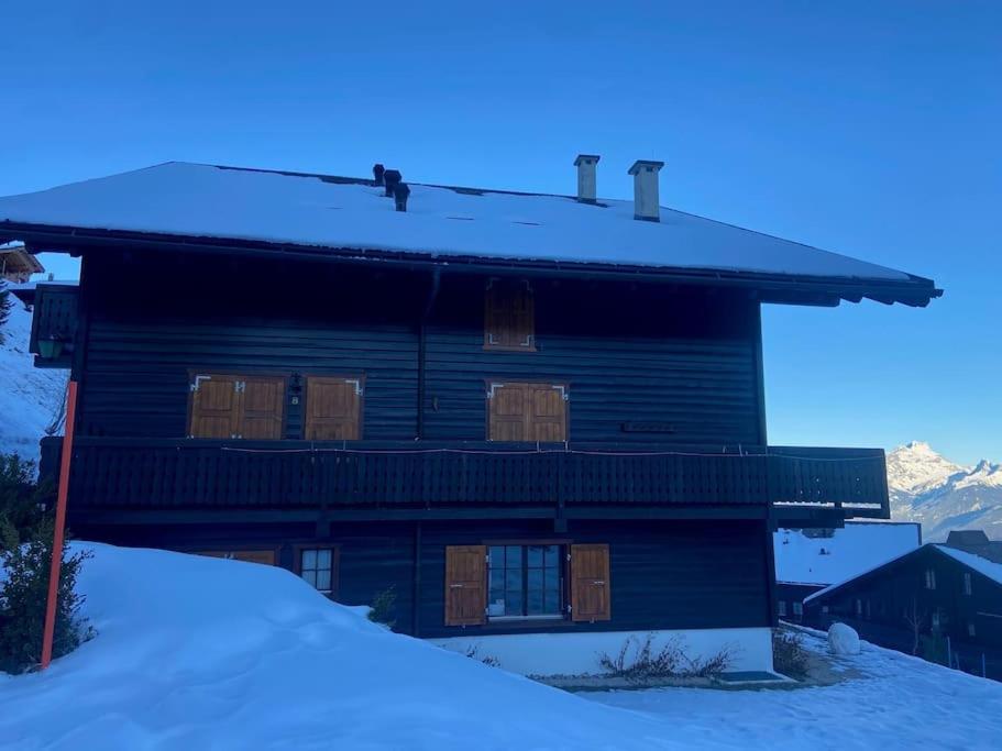 une grande maison en bois avec de la neige au sol dans l'établissement Appartement Duplex Les Bleuets K10, à Val dʼIlliez