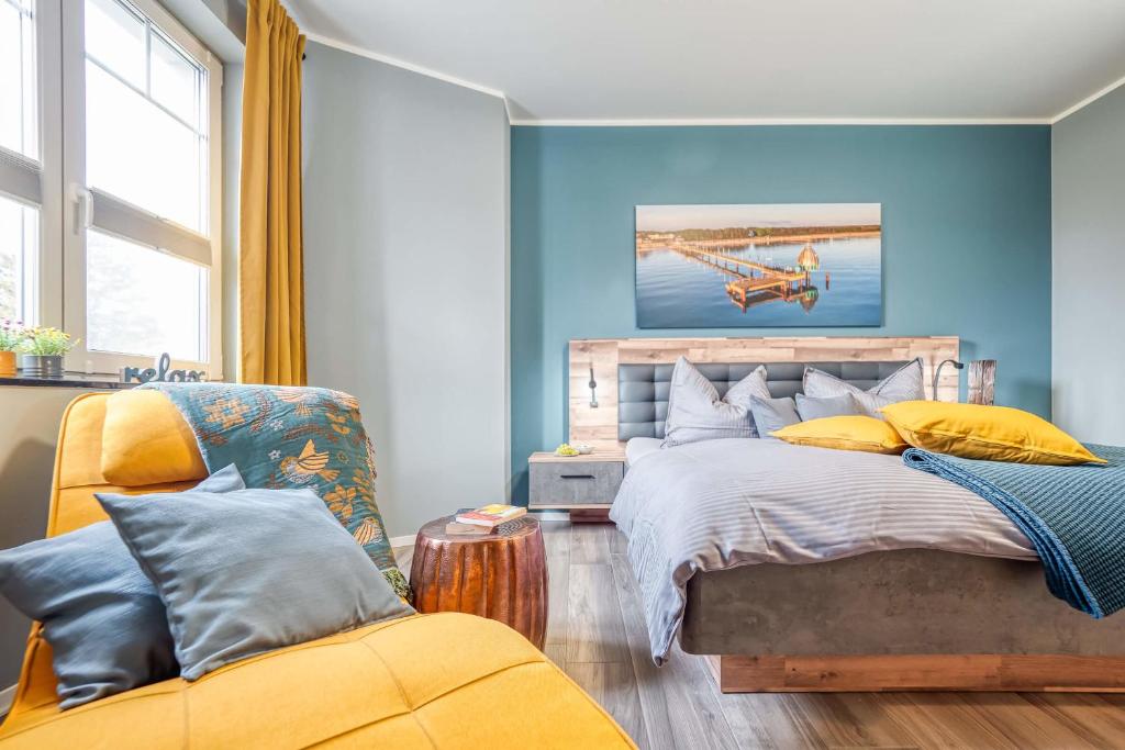 a bedroom with blue walls and a bed with yellow pillows at Strandstraße 16 - Wohnung 3 in Zingst