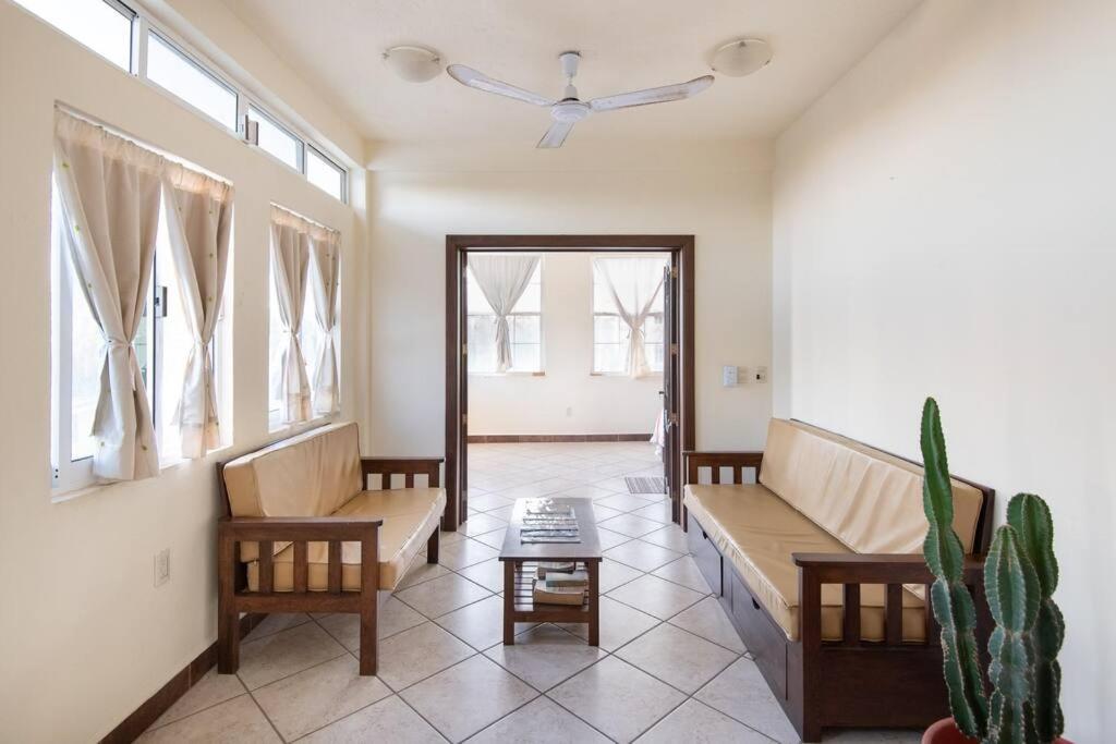 a living room with benches and a ceiling fan at Casa Vista Al Mar - 2nd Floor - Ocean View in Puerto Escondido