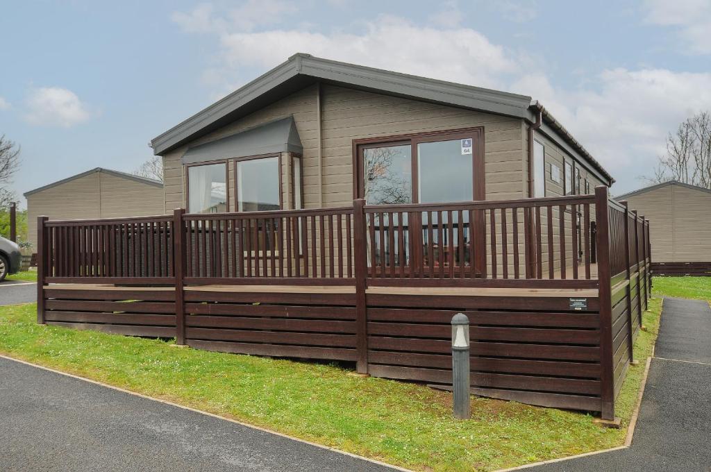 a small house with a wooden fence and a parking meter at Lodge 64 at Riviera Bay Coastal Retreat in Brixham