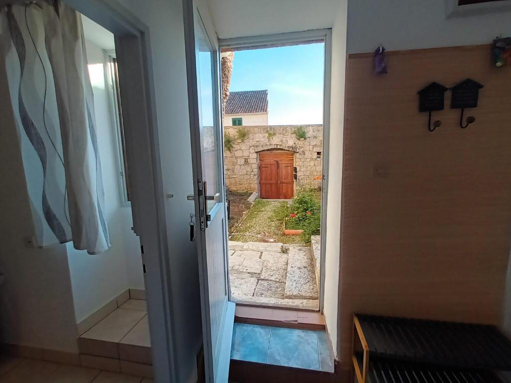 a door leading to a courtyard with a wooden door at Apartman Burte, Komiža in Komiža