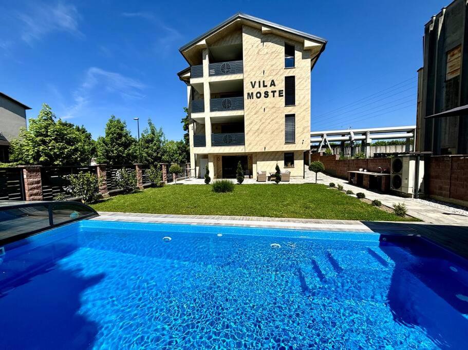 a building with a swimming pool in front of a building at Villa Moste 3-Free parking&pool in Ljubljana