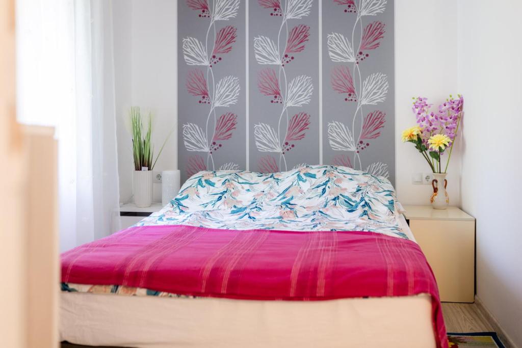 斯盧尼的住宿－Apartman Milka，一间卧室配有一张带粉红色棉被的床