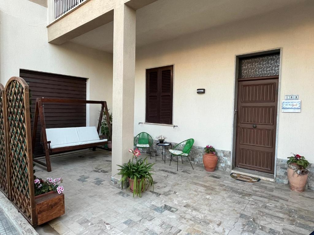 une terrasse avec un banc, une table et des chaises dans l'établissement Al Manzil, à Locogrande