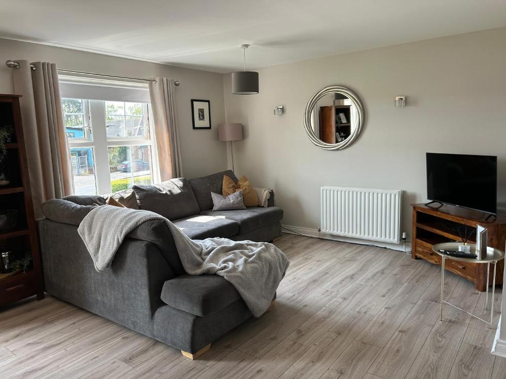 a living room with a couch and a television at Slane Stay, Belfast in Belfast