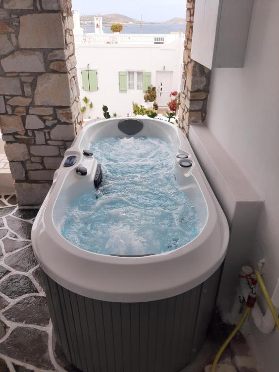 a jacuzzi tub in the corner of a building at studios FLORA in naoussa paros in Naousa