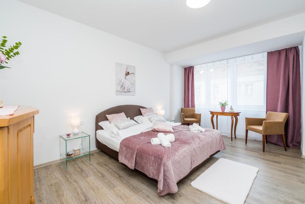 1 dormitorio con 1 cama, mesa y sillas en Perla Hradce 202, en Hradec Králové