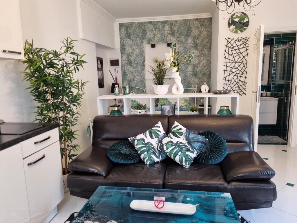 ein Wohnzimmer mit einem braunen Ledersofa mit Kissen in der Unterkunft App Paris 5 in Umag