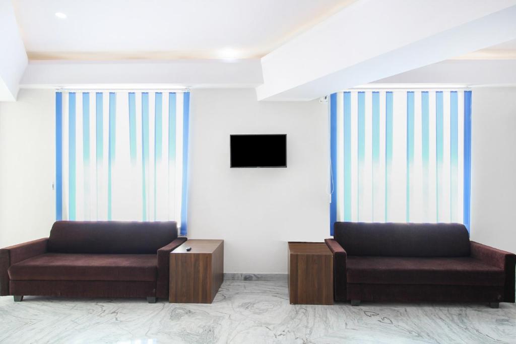 a waiting room with two chairs and a tv at OYO Hotel Lotus Prime in Jaipur