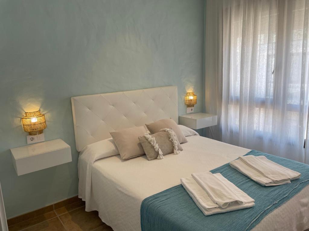 a bedroom with a bed with two towels on it at El Escondido de Zahara in Zahara de los Atunes