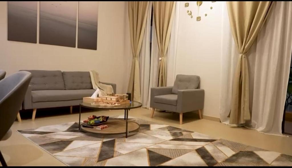 een woonkamer met een bank en een tafel en stoelen bij خليج مسقط in Qantab