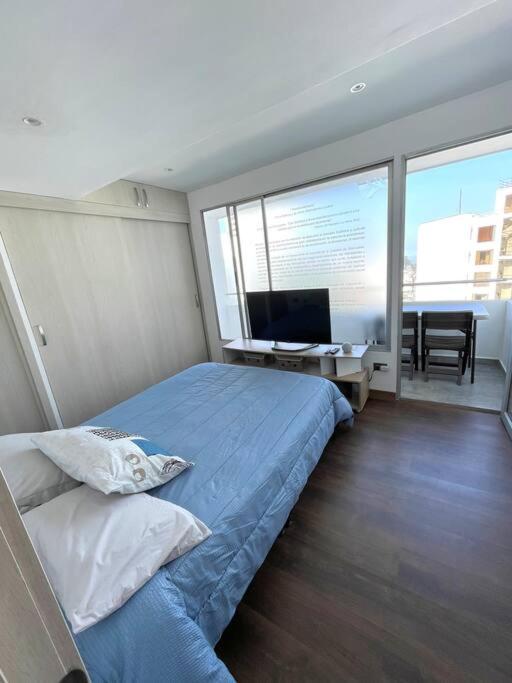 een slaapkamer met een bed en een bureau met een televisie bij Loft de lujo,Vista panorámica in Manizales