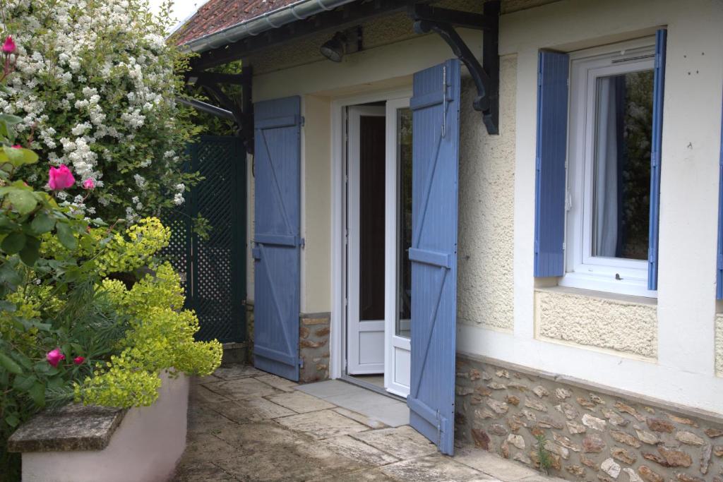an open door of a house with blue shutters at Clair logis in Giverny