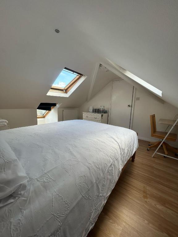 a bedroom with a large white bed and a skylight at Blissful 1-bedroom entire place in Cambridge