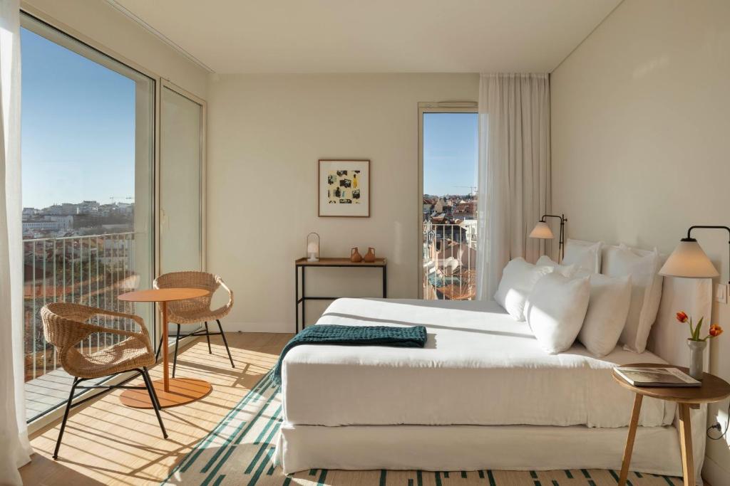 ein Schlafzimmer mit einem großen Bett und einem Balkon in der Unterkunft Pátio do Tijolo in Lissabon