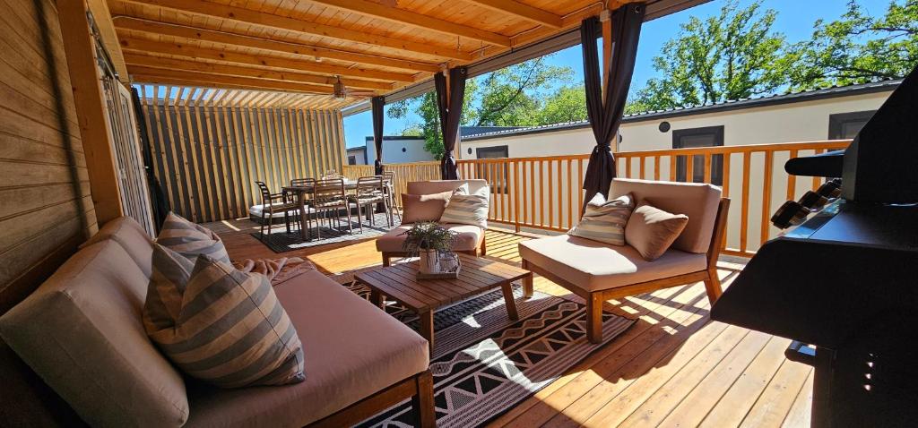 a screened in porch with two couches and a table at 250 mobile home Selce in Selce