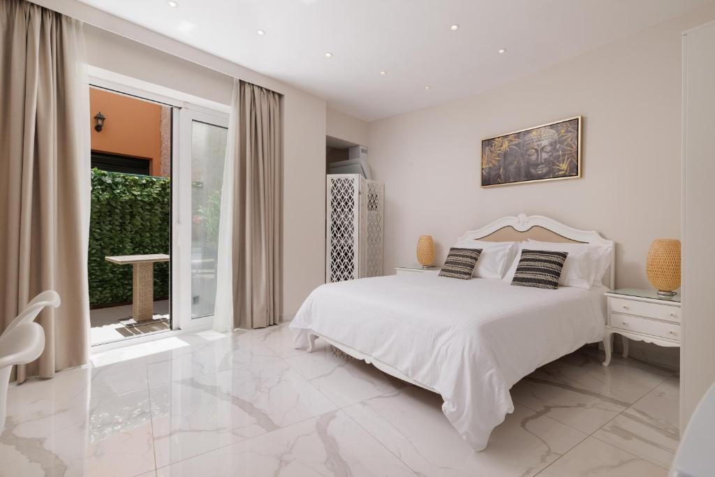 a white bedroom with a white bed and a window at Corfu Town Luxury Studios -D in Corfu Town