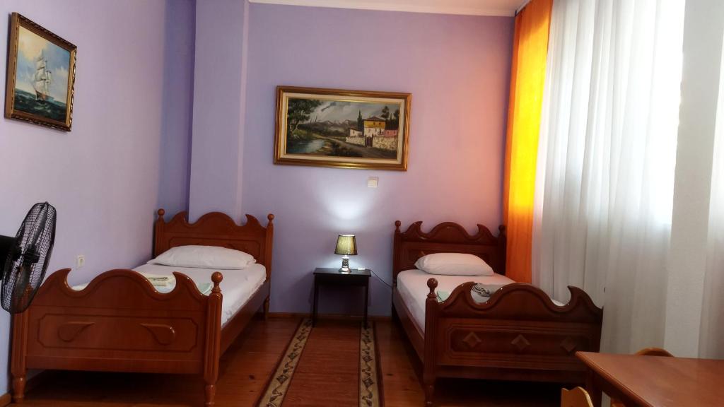 2 camas en una habitación con paredes moradas en LEVI Apartment, en Pogradec