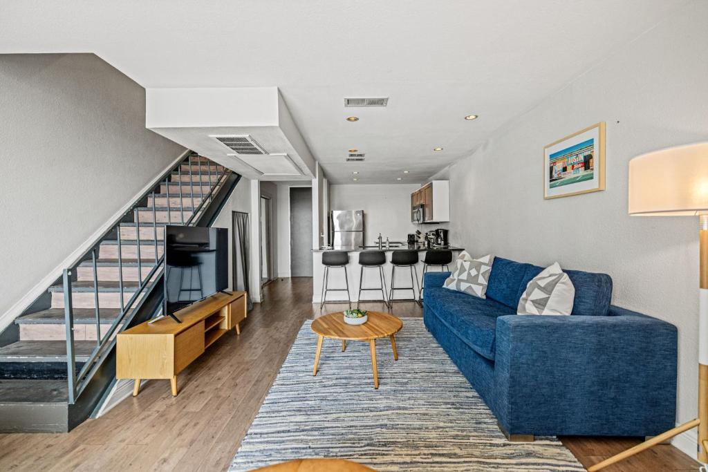 奥斯汀Littlefield Lofts, Hosted by Placemakr - 6th St的客厅里有一张蓝色的沙发和一座楼梯