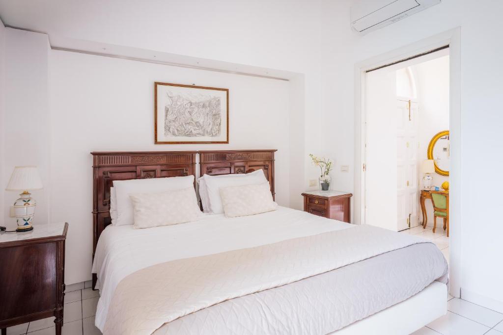 Un dormitorio blanco con una cama grande y una ventana en Maison Sersale, en Sorrento
